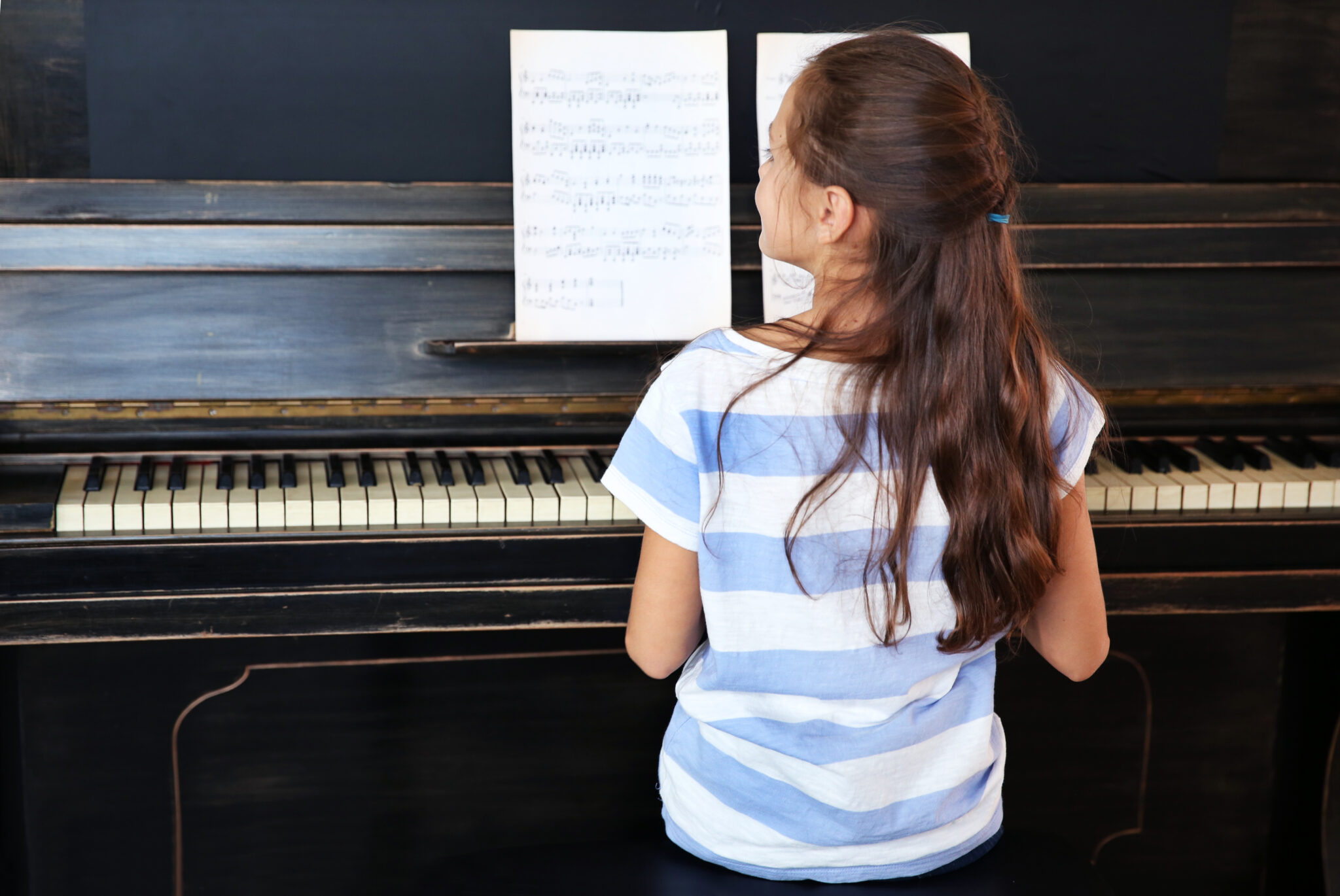 Mädchen übt konzentriert am Klavier