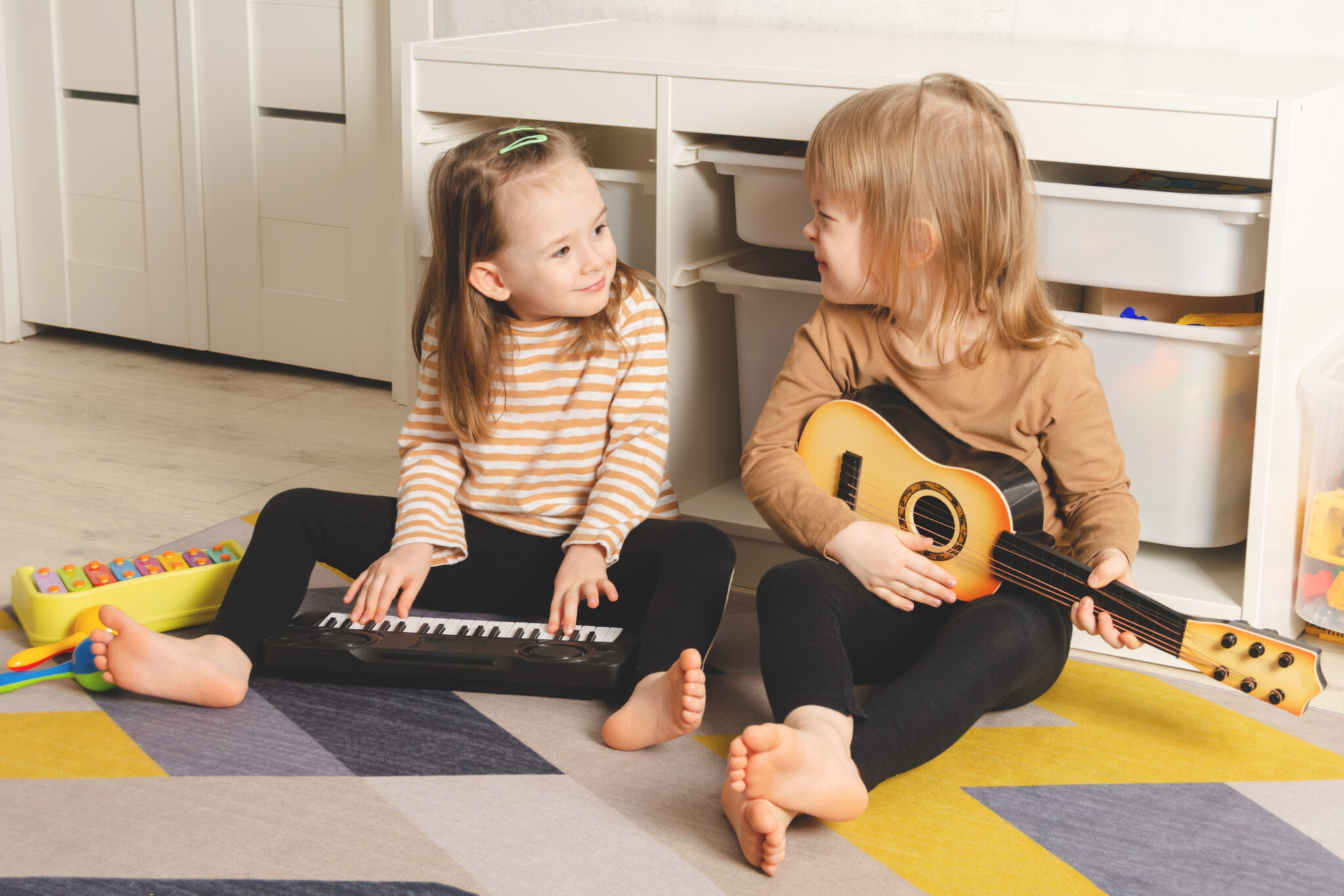 Zwei Kindergartenkinder entdecken zusammen kleine Instrumente