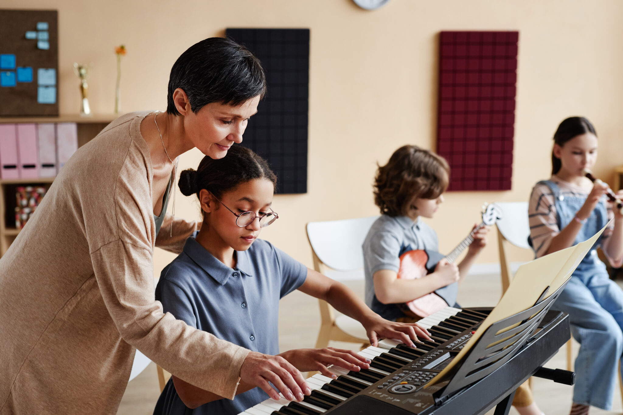 Lehrerin übt mit Kindern die verschiedene Instrumente spielen